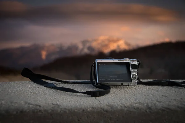 Pequeno tamanho bolso câmera digital fotografar por do sol sobre montanhas — Fotografia de Stock