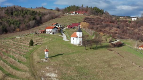 Vinhedo e capela na encosta de Pohorje, perto de Slovenska Bistrica, Eslovênia, campo rural no final do outono, vista aérea — Vídeo de Stock