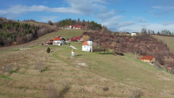 Kapel van Sveti Rok in Kovaca vas boven Slovenska Bistrica, met wijngaarden van Pohorje wijnbouwgebied, uitzicht vanuit de lucht — Stockvideo