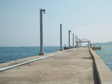 Deniz/okyanus mavi gökyüzü arka plan beton iskelede.