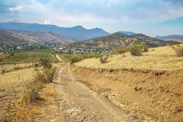 Estrada de terra nas montanhas e vinhas — Fotografia de Stock