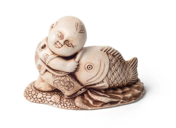 Netsuke van de jongen met grote vis. Geïsoleerd. Een miniatuur Skulptur — Stockfoto