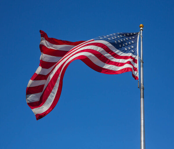 Proud flag  of United States of America waving on the wind on cl