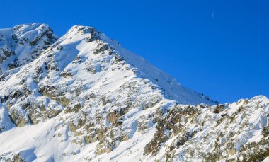Bulgaristan'daki Rila karlı yamaçları güneşli bir günde