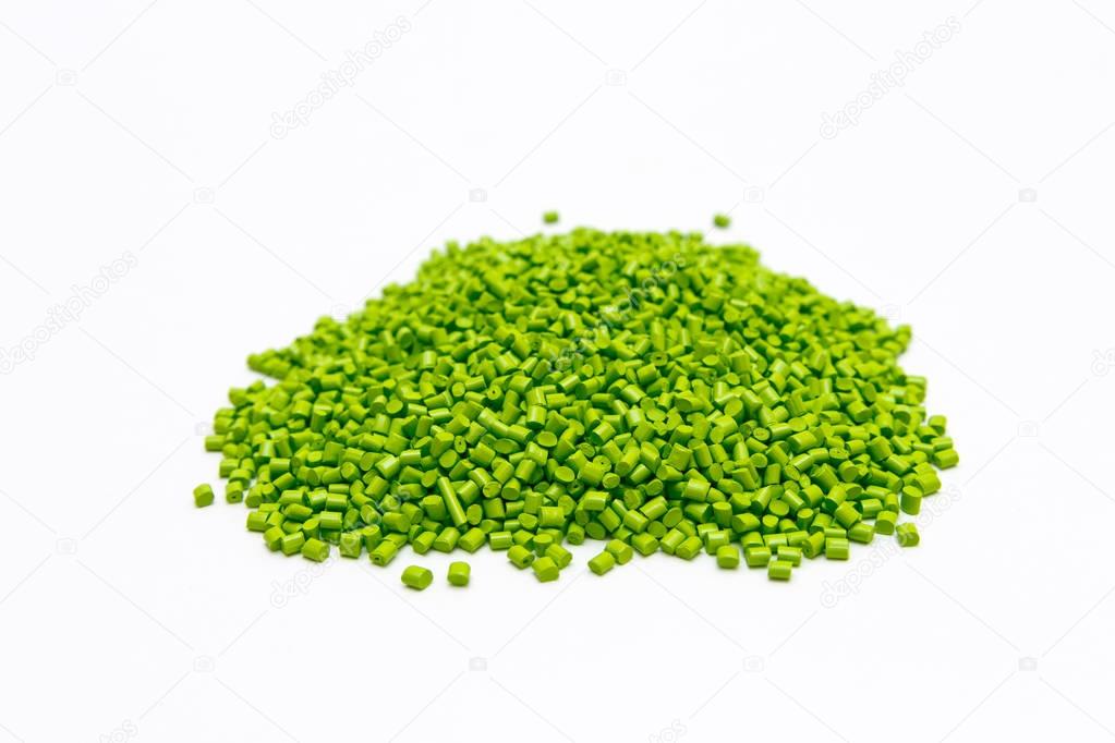 Green plastic pellets on a white background. Polymeric dye for p