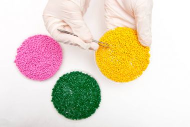 Plastik granül. Renklendirici polimer granül içinde için. Ellerinde eldiven ve cımbız ile plastik granül