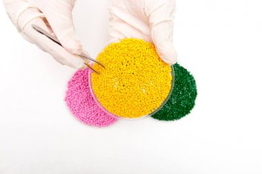 Plastik granül. Renklendirici polimer granül içinde için. Ellerinde eldiven ve cımbız ile plastik granül