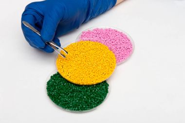 Plastik granül. Renklendirici polimer granül içinde için. Ellerinde eldiven ve cımbız ile plastik granül