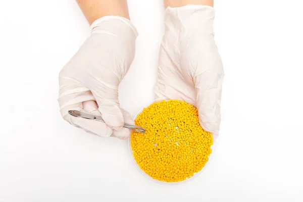 Plastikkugeln. Farbstoff für Polymere in Granulaten. Kunststoffpellets in den Händen mit Handschuhen und Pinzette — Stockfoto