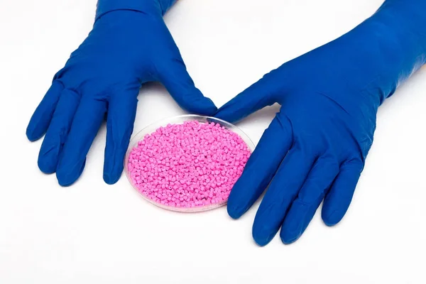 Pelotas de plástico. Colorente para polímeros em granulos.Pelotas de plástico nas mãos com luvas — Fotografia de Stock