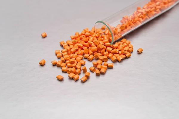 Plastpallar. Färgämne för polymerer i granulat. Orange gran — Stockfoto