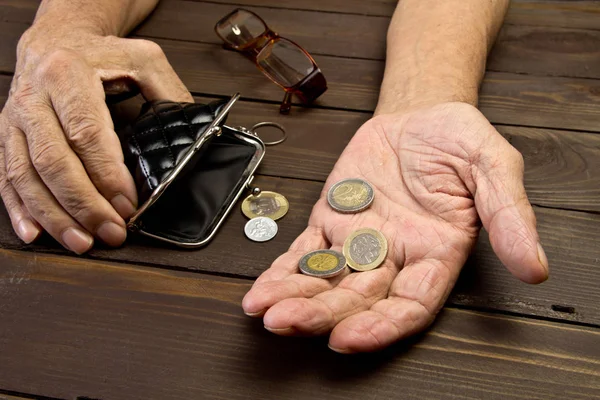 Osoby w podeszłym wieku przytrzyma monety na stary pusty portfel. Ręka — Zdjęcie stockowe
