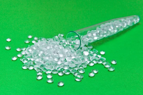 Transparant polyethyleen korrels op een groene achtergrond. De conc — Stockfoto