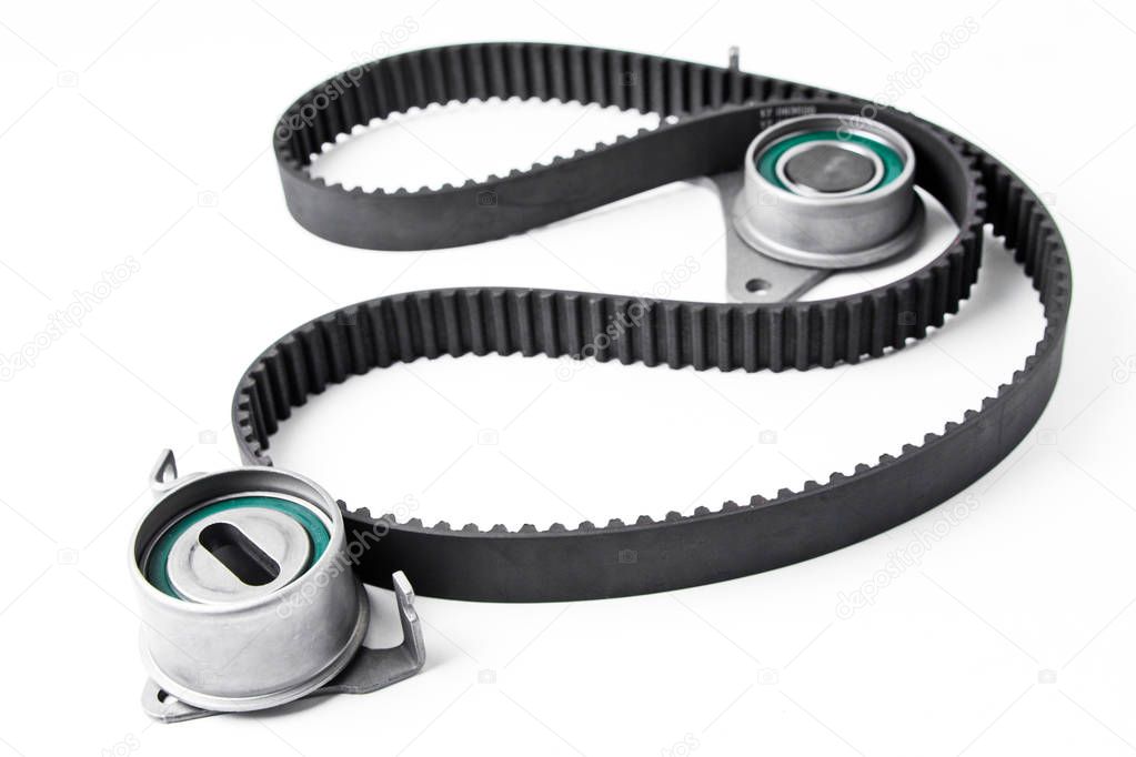  Kit of timing belt with rollers on a light background.
