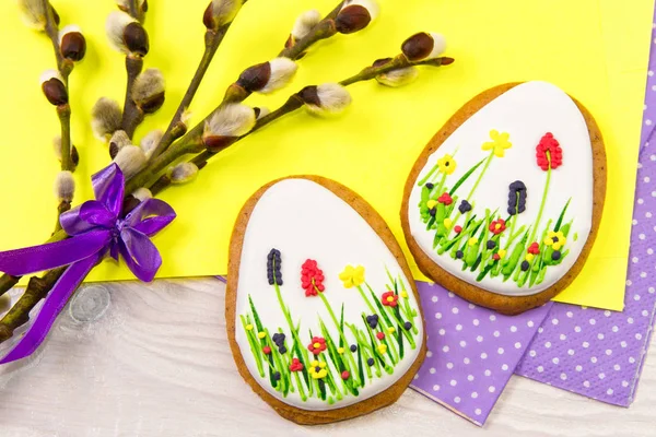 Gingerbread Easter eggs along with a willow twig on yellow and p — Stock Photo, Image