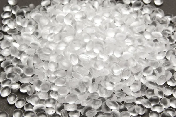 Transparent Polyethylen granulat på mørk. HDPE Plastic pellets . Stock-billede