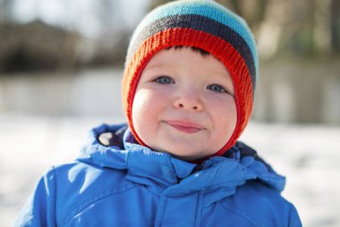 Kış sıcak giyinmiş çocuk karlı bir sokakta yürüme