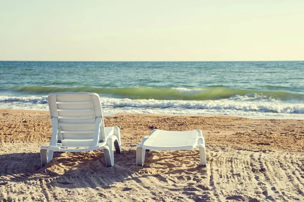Twee ligstoelen op een strand, kijkend uit naar zee — Stockfoto