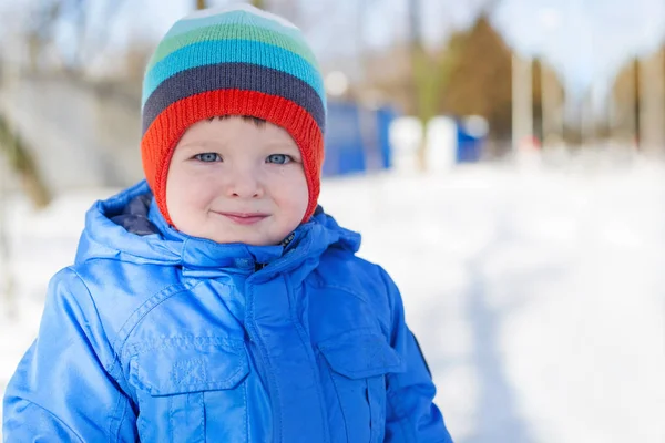 Kış sıcak giyinmiş çocuk karlı bir sokakta yürüme