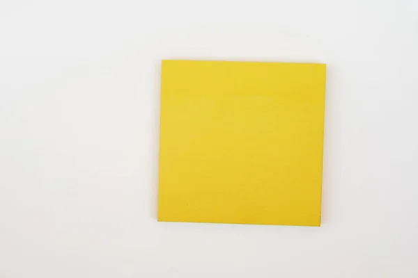 Bloco de notas amarelo em um fundo branco — Fotografia de Stock