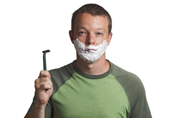 Pretty young man with shaving foam on his cheeks holding a razor — Stock Photo, Image