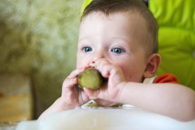 küçük çocuk çocuk sandalyede oturan yiyor