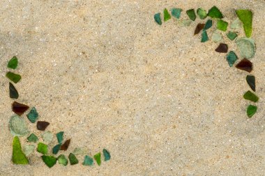 bir çerçeve şeklinde ıslak kum plajında denizin kenarında parlak renkli cam parçaları