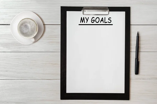 My goals list on note pad paper with pen and coffee on wooden table — Stock Photo, Image