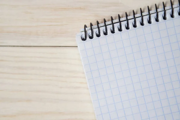 Notebook in a cage on a wooden background — Stock Photo, Image