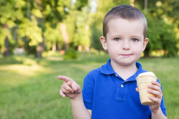 Милый малыш, ешь мороженое. Ребенок ест мороженое на открытом воздухе — стоковое фото