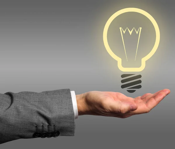 実業家が手にアイデア電球を点灯 — ストック写真