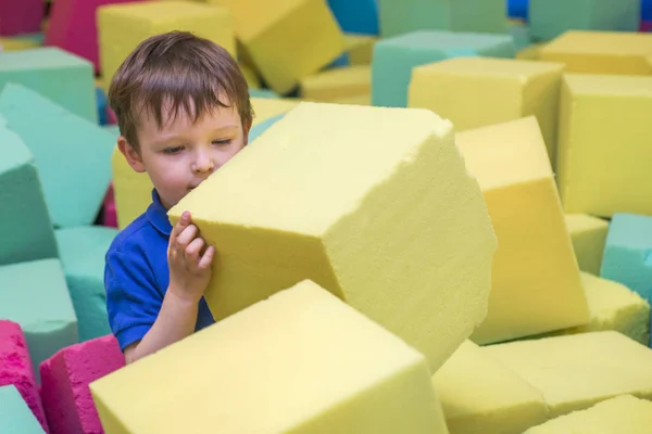 Маленький ребенок играет с мягкими блоками на крытой детской площадке — стоковое фото