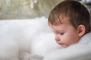 Banyoda Yüzme mutlu küçük bebek. Bir banyo köpük tam banyo bebek portresi