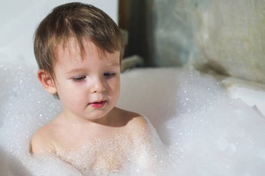 Banyoda Yüzme mutlu küçük bebek. Bir banyo köpük tam banyo bebek portresi