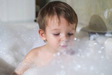 Banyoda Yüzme mutlu küçük bebek. Bir banyo köpük tam banyo bebek portresi