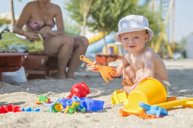 küçük çocuk tropik Sahilde plaj oyuncakları ile oynarken