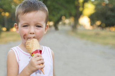 Sevimli yürümeye başlayan çocuk yemek dondurma. kirli yüzü dondurma yiyen çocuk