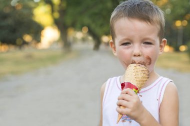 Sevimli yürümeye başlayan çocuk yemek dondurma. kirli yüzü dondurma yiyen çocuk