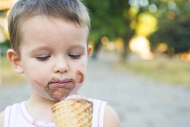 Sevimli yürümeye başlayan çocuk yemek dondurma. kirli yüzü dondurma yiyen çocuk