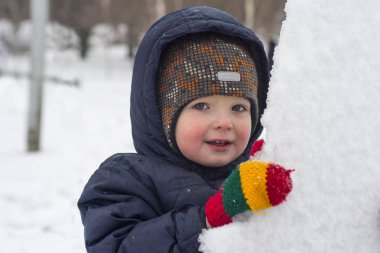 küçük bir çocuk kar veya buz parçaları dışında görünüyor. Bir çocuk kar ile çalış