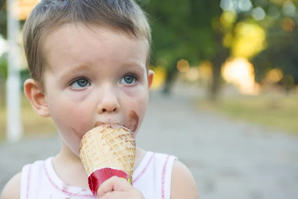 Милый мальчик Тоддлер ест мороженое. ребенок с грязным лицом ест мороженое — стоковое фото