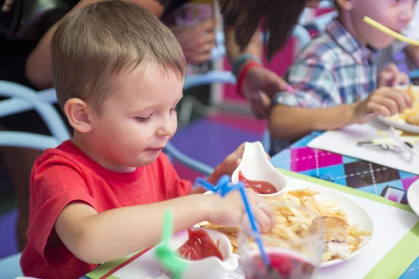 Anak TK yang sehat dan lucu makan duduk di sekolah atau di kafe anak-anak. Anak yang bahagia makan makanan organik dan vegetarian yang sehat di restoran. Masa kecil, konsep kesehatan — Stok Foto