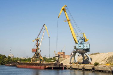 Deniz terminalinden dev turnalar. Lojistik işi. Büyük vinçler ve konteynırlar, güneşli yaz günü
