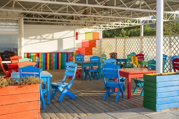 Café de praia com cadeiras coloridas. Terraço colorido no restaurante moderno em cores extravagantes — Fotografia de Stock