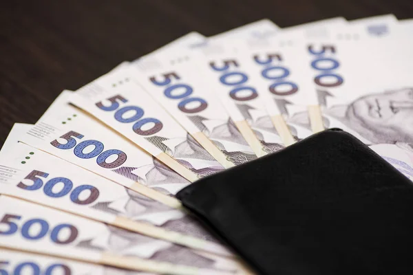 Cüzdanında Ukrayna Hryvnia senetleri var. Para arkaplanı, Ukrayna 'nın ahşap arka planında kara cüzdan, Ukrayna para birimi