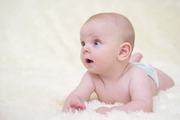 Pequeño bebé gracioso acostado en una manta. Niño recién nacido relajándose en la cama — Foto de Stock