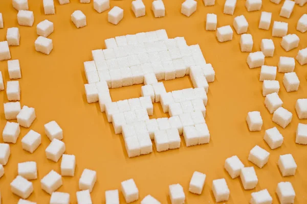 Sugar cubes laid out in shape of skull. Concept that sugar and sweets are dangerous. Sugar and sweet leads to diabetes
