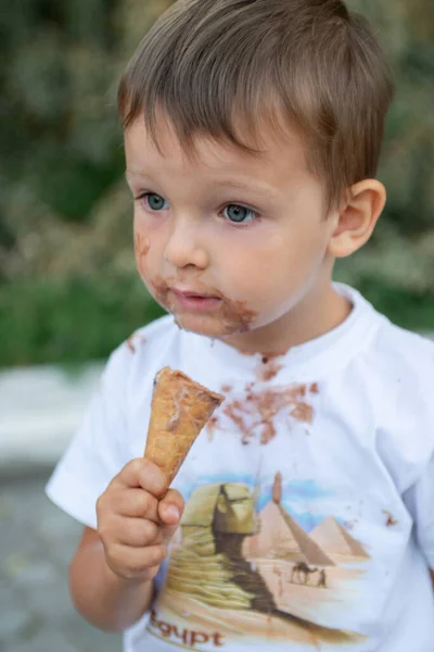 Ragazzo felice che mangia gelato. Ragazzo con un viso sporco mangiare gelato — Foto Stock