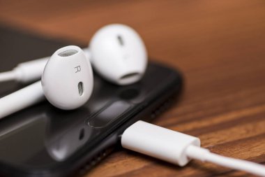 Akıllı telefon ve kulaklıklar masada. Müzik dinlemek için kulaklıklı cep telefonu..