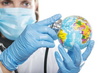 Dünya gezegenini dinlemek için steteskop kullanan bir doktor teşhis koydu, küresel sağlık kontrolü kavramı. Küresel sağlık hizmeti kavramı.